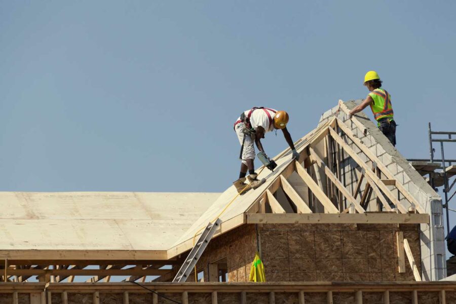 Restoration contractors rebuilding a roof