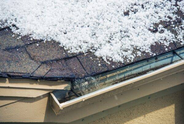A Texas home with melting snow on the roof, illustrating potential ice dam formation.